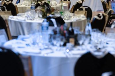 Miniature Dîner Salle Capella Entrée d'un bâtiment avec escalier central, écrans d'affichage, plantes décoratives et sol en parquet.