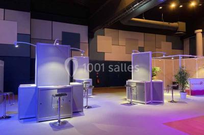 Miniature Salle Capella Entrée d'un bâtiment avec escalier central, écrans d'affichage, plantes décoratives et sol en parquet.