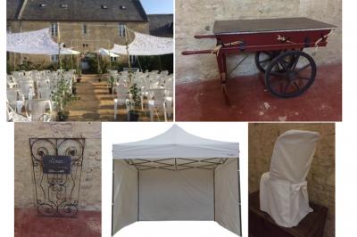 Vue nocturne d'une porte monumentale en pierre éclairée, avec un bâtiment blanc visible en arrière-plan.