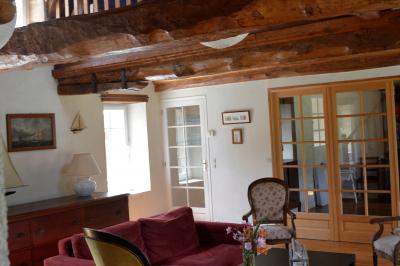 Vue nocturne d'une porte monumentale en pierre éclairée, avec un bâtiment blanc visible en arrière-plan.