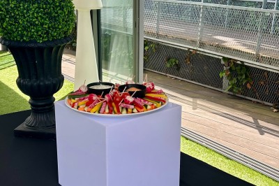 Miniature Location salle Villeurbanne (Rhône) - Le Pavillon De La Soie #25 Terrasse avec pergola en bois, tables et chaises noires, sol en bois et gazon artificiel, ciel bleu en arrière-plan.