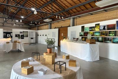 Salle de réunion avec tables et chaises disposées en U, grand écran blanc, plantes et buffet en arrière-plan.