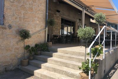 Salle de réunion avec tables et chaises disposées en U, grand écran blanc, plantes et buffet en arrière-plan.
