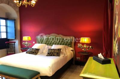 Un vase de fleurs sur une table en bois dans une salle avec poutres apparentes, un panneau ’Bienvenue’ au premier plan.