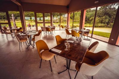 Un vase de fleurs sur une table en bois dans une salle avec poutres apparentes, un panneau ’Bienvenue’ au premier plan.