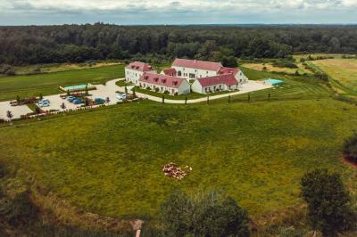 Un vase de fleurs sur une table en bois dans une salle avec poutres apparentes, un panneau ’Bienvenue’ au premier plan.