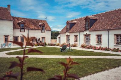 Un vase de fleurs sur une table en bois dans une salle avec poutres apparentes, un panneau ’Bienvenue’ au premier plan.