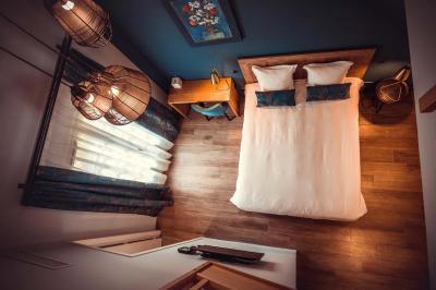 Un vase de fleurs sur une table en bois dans une salle avec poutres apparentes, un panneau ’Bienvenue’ au premier plan.