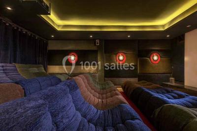 Cloison décorative ajourée en bois sombre devant une baignoire avec robinetterie métallique, lumière naturelle en arrière…