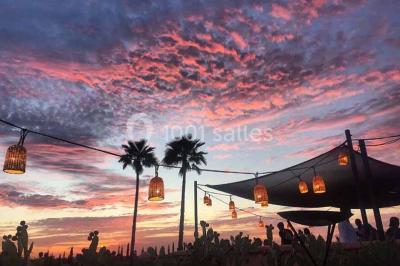 Cloison décorative ajourée en bois sombre devant une baignoire avec robinetterie métallique, lumière naturelle en arrière…