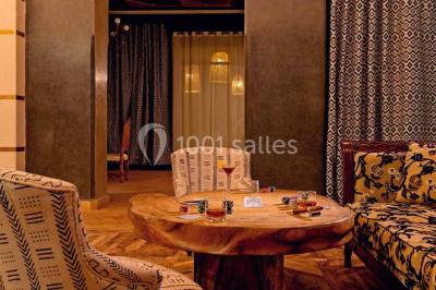 Cloison décorative ajourée en bois sombre devant une baignoire avec robinetterie métallique, lumière naturelle en arrière…