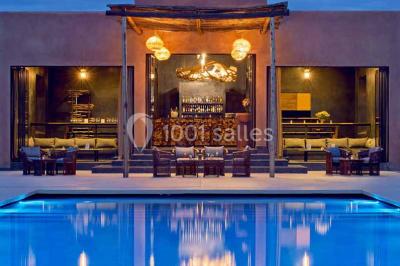 Cloison décorative ajourée en bois sombre devant une baignoire avec robinetterie métallique, lumière naturelle en arrière…