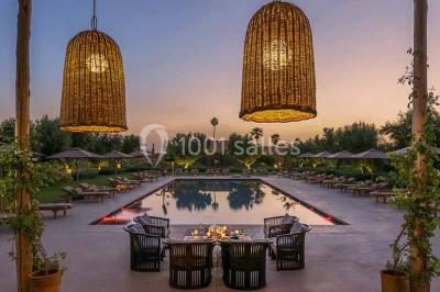 Cloison décorative ajourée en bois sombre devant une baignoire avec robinetterie métallique, lumière naturelle en arrière…