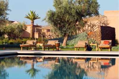 Cloison décorative ajourée en bois sombre devant une baignoire avec robinetterie métallique, lumière naturelle en arrière…