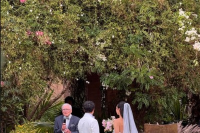 Cloison décorative ajourée en bois sombre devant une baignoire avec robinetterie métallique, lumière naturelle en arrière…