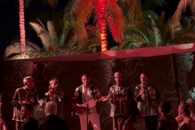 Cloison décorative ajourée en bois sombre devant une baignoire avec robinetterie métallique, lumière naturelle en arrière…