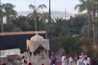 Cloison décorative ajourée en bois sombre devant une baignoire avec robinetterie métallique, lumière naturelle en arrière…
