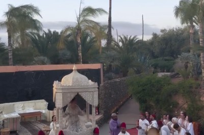 Cloison décorative ajourée en bois sombre devant une baignoire avec robinetterie métallique, lumière naturelle en arrière…