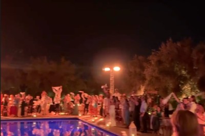 Cloison décorative ajourée en bois sombre devant une baignoire avec robinetterie métallique, lumière naturelle en arrière…