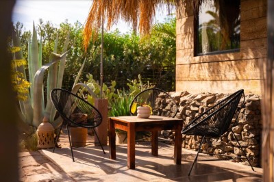 Cloison décorative ajourée en bois sombre devant une baignoire avec robinetterie métallique, lumière naturelle en arrière…