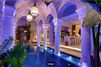 Cloison décorative ajourée en bois sombre devant une baignoire avec robinetterie métallique, lumière naturelle en arrière…