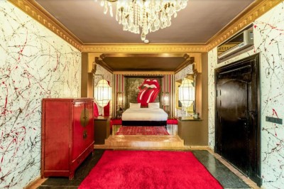 Cloison décorative ajourée en bois sombre devant une baignoire avec robinetterie métallique, lumière naturelle en arrière…