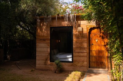 Cloison décorative ajourée en bois sombre devant une baignoire avec robinetterie métallique, lumière naturelle en arrière…