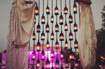 Cloison décorative ajourée en bois sombre devant une baignoire avec robinetterie métallique, lumière naturelle en arrière…