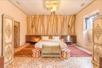 Cloison décorative ajourée en bois sombre devant une baignoire avec robinetterie métallique, lumière naturelle en arrière…