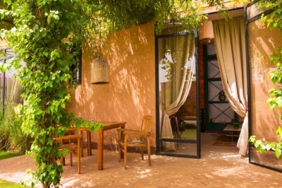 Cloison décorative ajourée en bois sombre devant une baignoire avec robinetterie métallique, lumière naturelle en arrière…