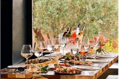 Cloison décorative ajourée en bois sombre devant une baignoire avec robinetterie métallique, lumière naturelle en arrière…