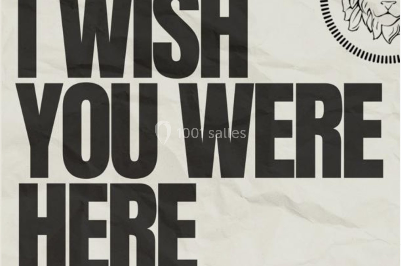 Texte en majuscules ’I WISH YOU WERE HERE’ sur fond texturé beige, avec un logo de lion en haut à droite.