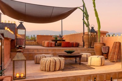 Cloison décorative ajourée en bois sombre devant une baignoire avec robinetterie métallique, lumière naturelle en arrière…