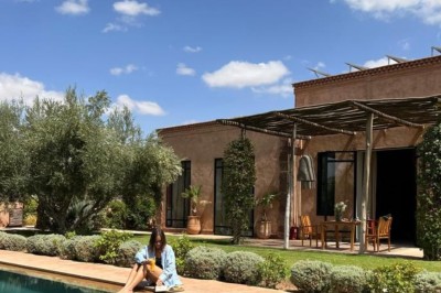 Cloison décorative ajourée en bois sombre devant une baignoire avec robinetterie métallique, lumière naturelle en arrière…