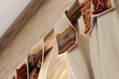 Cloison décorative ajourée en bois sombre devant une baignoire avec robinetterie métallique, lumière naturelle en arrière…