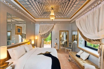 Cloison décorative ajourée en bois sombre devant une baignoire avec robinetterie métallique, lumière naturelle en arrière…