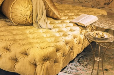 Cloison décorative ajourée en bois sombre devant une baignoire avec robinetterie métallique, lumière naturelle en arrière…