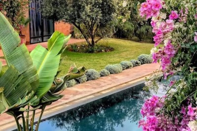 Cloison décorative ajourée en bois sombre devant une baignoire avec robinetterie métallique, lumière naturelle en arrière…