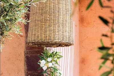 Cloison décorative ajourée en bois sombre devant une baignoire avec robinetterie métallique, lumière naturelle en arrière…