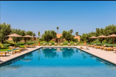 Cloison décorative ajourée en bois sombre devant une baignoire avec robinetterie métallique, lumière naturelle en arrière…