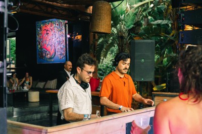 Cloison décorative ajourée en bois sombre devant une baignoire avec robinetterie métallique, lumière naturelle en arrière…