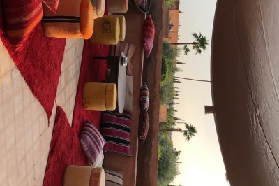 Cloison décorative ajourée en bois sombre devant une baignoire avec robinetterie métallique, lumière naturelle en arrière…