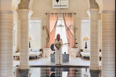 Cloison décorative ajourée en bois sombre devant une baignoire avec robinetterie métallique, lumière naturelle en arrière…