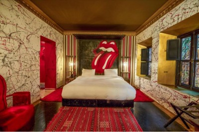 Cloison décorative ajourée en bois sombre devant une baignoire avec robinetterie métallique, lumière naturelle en arrière…