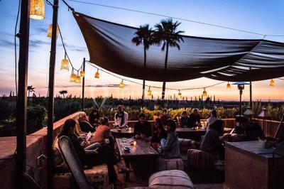 Cloison décorative ajourée en bois sombre devant une baignoire avec robinetterie métallique, lumière naturelle en arrière…