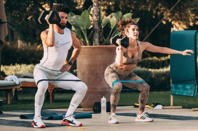 Cloison décorative ajourée en bois sombre devant une baignoire avec robinetterie métallique, lumière naturelle en arrière…