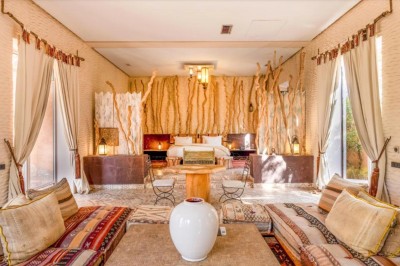 Cloison décorative ajourée en bois sombre devant une baignoire avec robinetterie métallique, lumière naturelle en arrière…