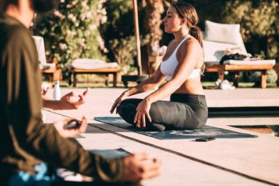 Cloison décorative ajourée en bois sombre devant une baignoire avec robinetterie métallique, lumière naturelle en arrière…