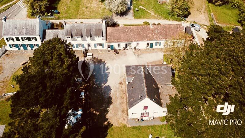 Vue aérienne d'un ensemble de bâtiments résidentiels entourés de verdure, prise par un drone.