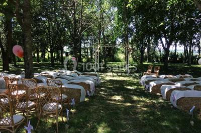 Tables décorées pour un événement avec chandeliers, compositions florales suspendues et lumière tamisée.